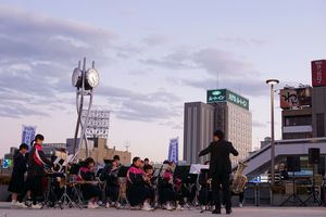 日が傾く中、点灯式に向けて平三中吹奏楽部が盛り上げる。