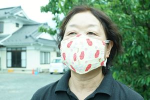 代表の菊地さん。果樹園だが、マスクはお魚さんだ。