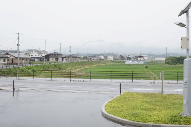 駅前には田んぼの中に住宅地がある。遠くには山も望める。