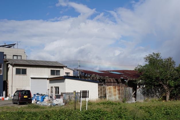 屋根のすぐ上に、虹がかかっている（伊達市内で）。