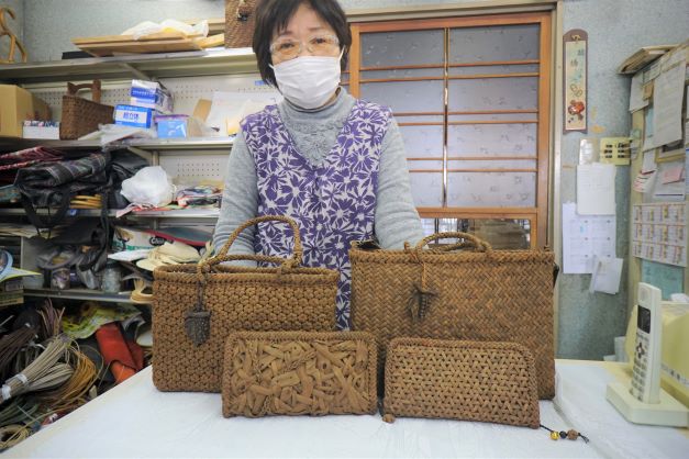 瀬戸物店の傍ら、山葡萄の編み組み細工を作る女性（「その２」に登場）。