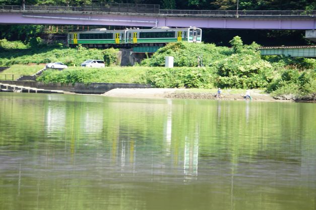 列車の手前左が渡し舟の船着き場。右手には釣りを楽しむ人も。