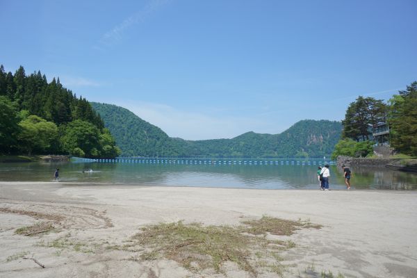 沼沢湖では、水に入って楽しむ家族が。